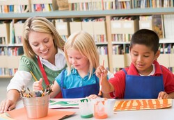 A teacher helping two students in art class